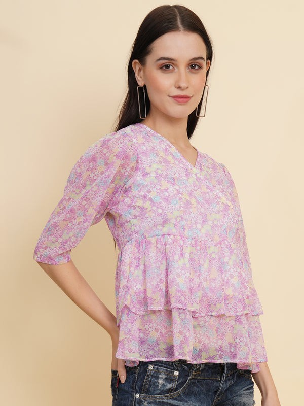  A vibrant purple women's top adorned with beautiful floral patterns. It features double ruffle detailing, creating an elegant and feminine look. The top is fully lined, providing comfort and a smooth fit. Perfect for adding a touch of color and style to any outfit