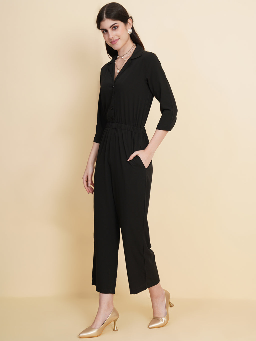 Get ready to make a bold statement with our black formal jumpsuit for women! Tailored in crepe, it features a coat collar with front buttoning and elasticated waist and two side pockets to slip in your essentials. This elegant piece combines sleekness and sophistication, perfect for official and casual wear.