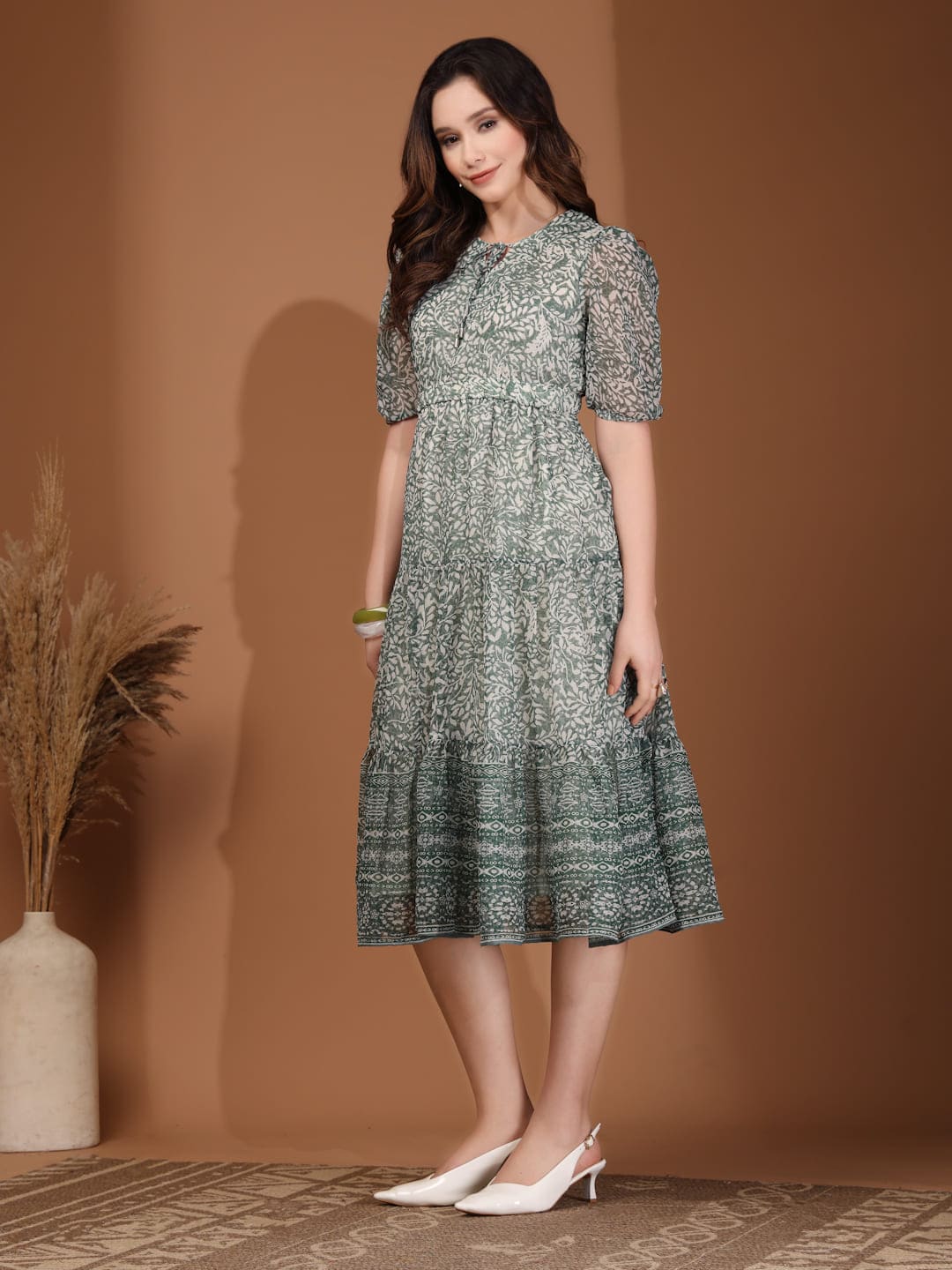 Woman wearing RAASSIO sage green floral printed chiffon tiered midi dress with attached lining side view