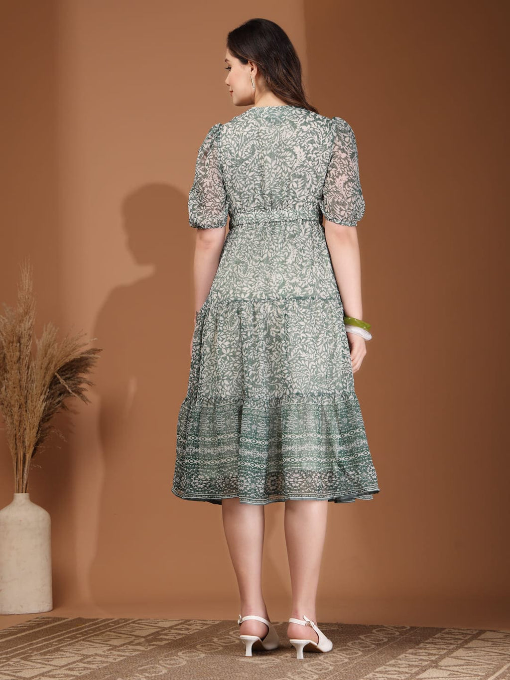 Woman wearing RAASSIO sage green floral printed chiffon tiered midi dress with attached lining back view