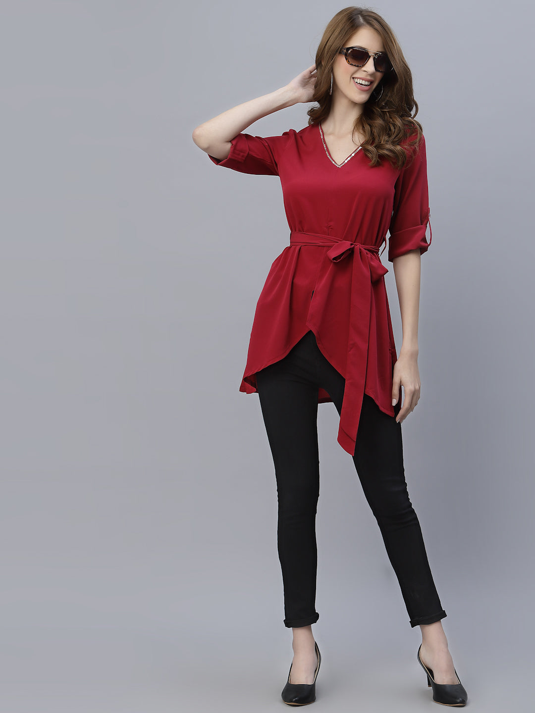 A Burgundy Color V Neck High Low Top With Belt is a stylish and fashionable garment that can be worn for various occasions. The top features a v-neckline, which creates a flattering and feminine look. The high low hemline adds a trendy touch to the design, making it perfect for a night out or a casual day look. The top also comes with a belt that cinches in the waist, creating a more defined silhouette.