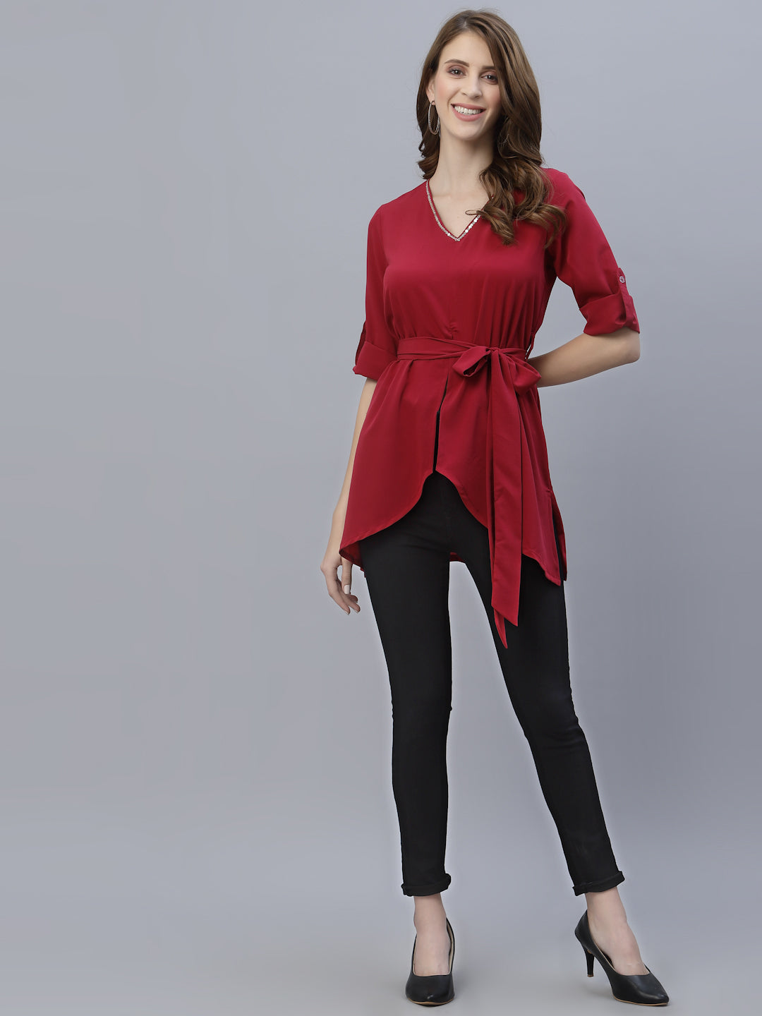 A Burgundy Color V Neck High Low Top With Belt is a stylish and fashionable garment that can be worn for various occasions. The top features a v-neckline, which creates a flattering and feminine look. The high low hemline adds a trendy touch to the design, making it perfect for a night out or a casual day look. The top also comes with a belt that cinches in the waist, creating a more defined silhouette.