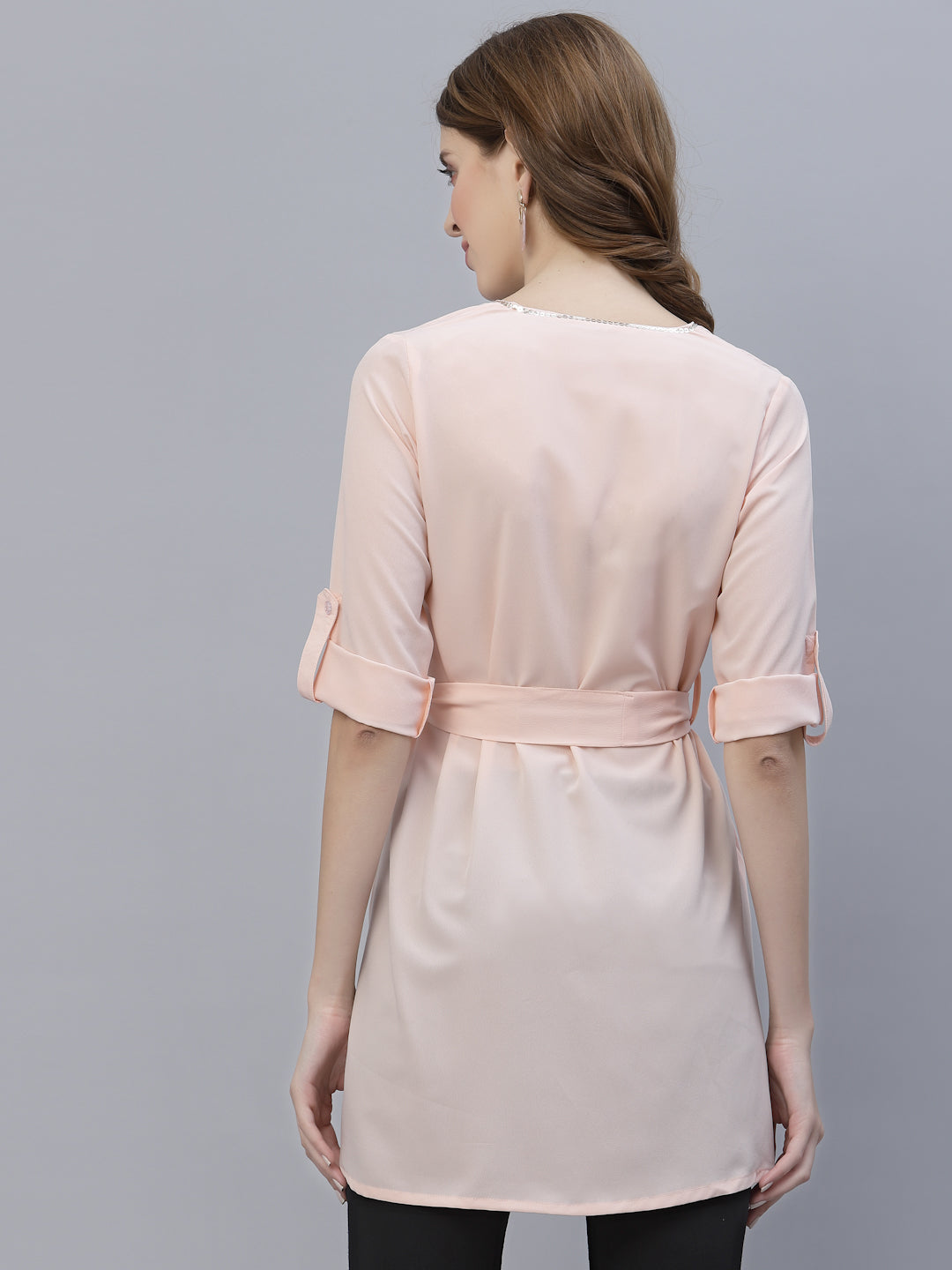 A Peach Color V Neck High Low Top With Belt is a stylish and fashionable garment that can be worn for various occasions. The top features a v-neckline, which creates a flattering and feminine look. The high low hemline adds a trendy touch to the design, making it perfect for a night out or a casual day look. The top also comes with a belt that cinches in the waist, creating a more defined silhouette.
