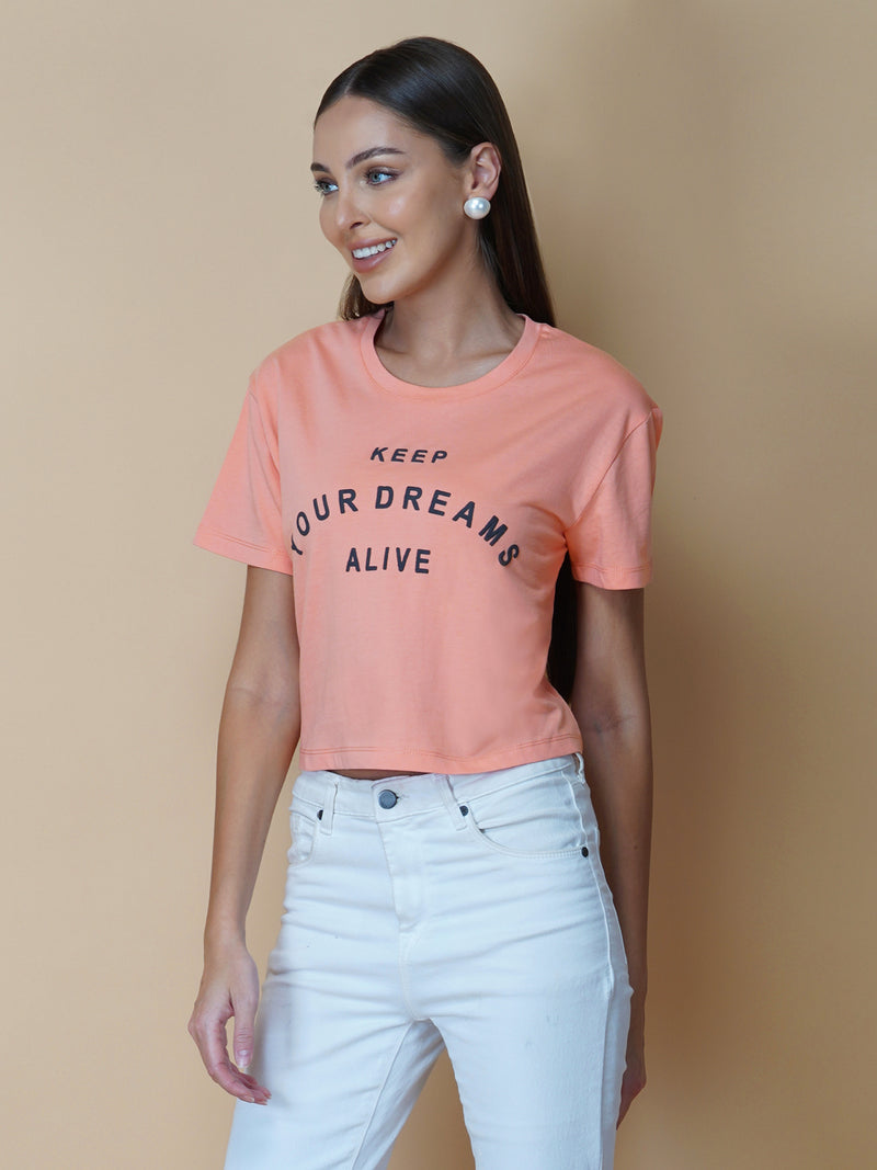 The Peach Color Quote T-Shirt for Women is a trendy and stylish addition to any wardrobe. Made from soft, breathable cotton fabric, this T-shirt is perfect for hot weather and provides excellent comfort and flexibility.  The shirt features a beautiful peach color, which adds a touch of femininity and sophistication. The shirt is designed with a simple round neck and short sleeves, making it a versatile option for any outfit.