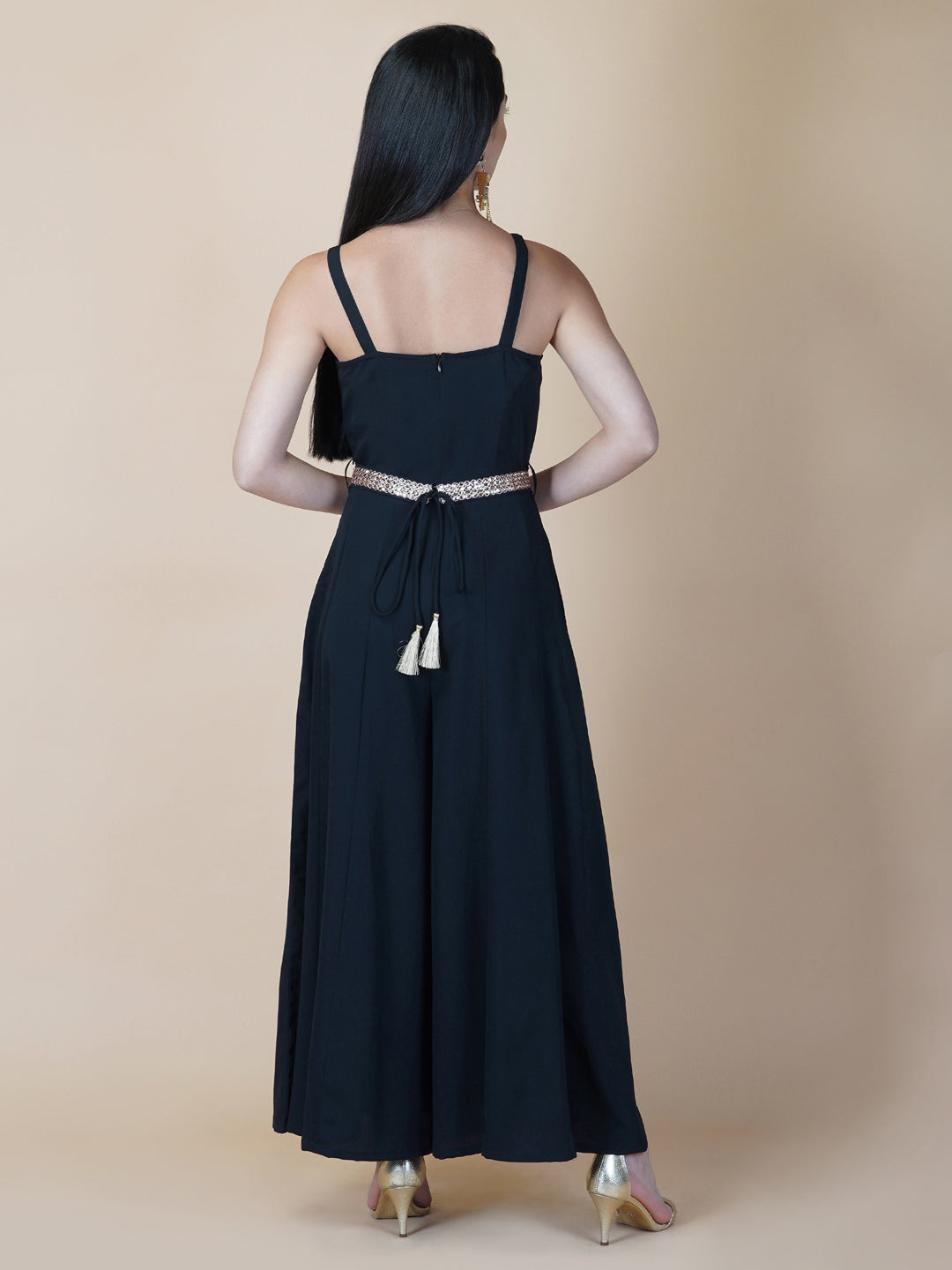 This black solid fit and flare women jumpsuit with an attached belt is a fashionable one-piece garment that combines the comfort of pants with the elegance of a dress. This jumpsuit features a fitted top that flares out into wide-leg pants, creating a flattering silhouette that accentuates the waist and elongates the legs.