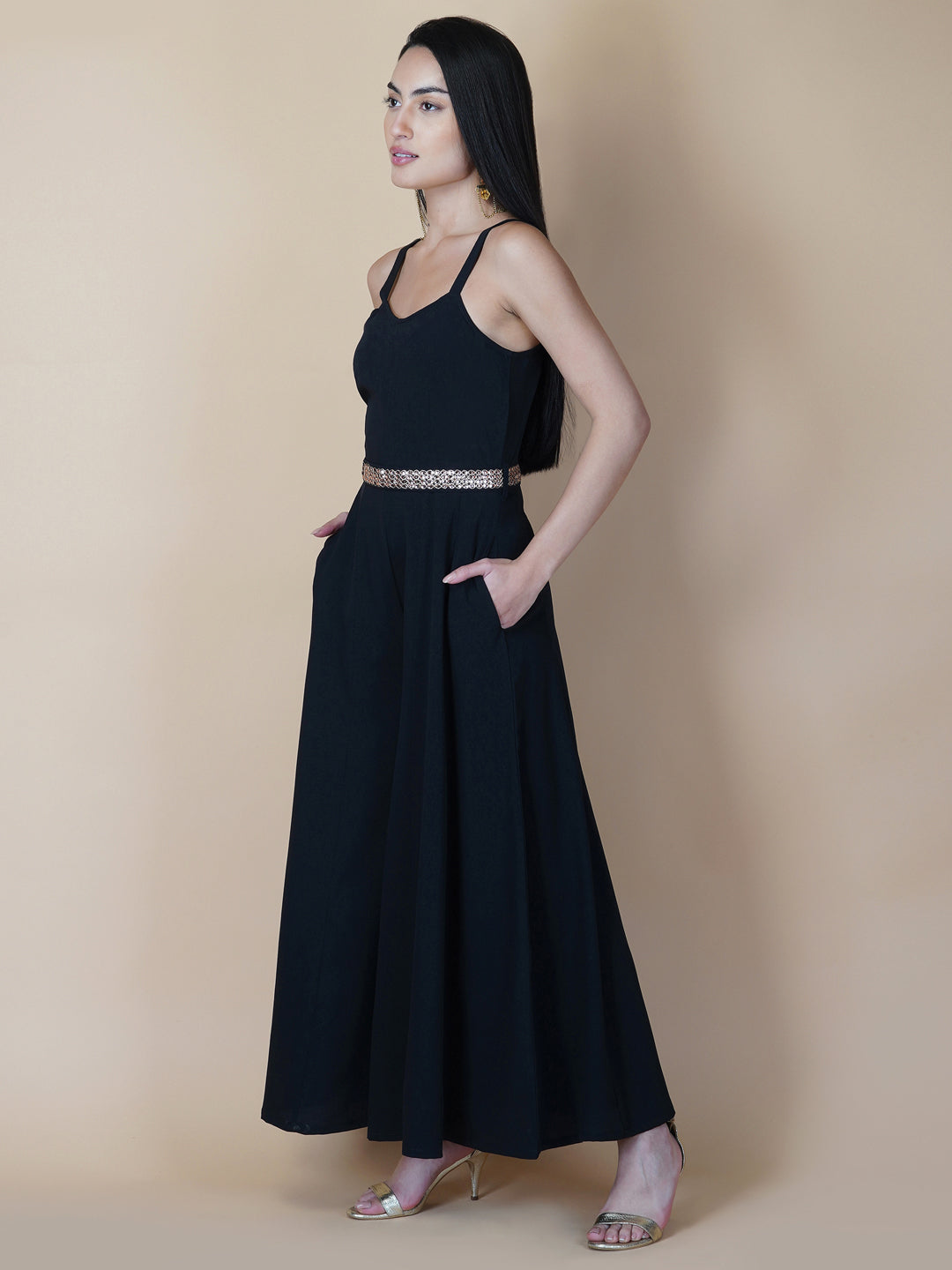 This black solid fit and flare women jumpsuit with an attached belt is a fashionable one-piece garment that combines the comfort of pants with the elegance of a dress. This jumpsuit features a fitted top that flares out into wide-leg pants, creating a flattering silhouette that accentuates the waist and elongates the legs.