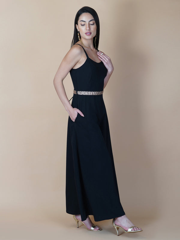 This black solid fit and flare women jumpsuit with an attached belt is a fashionable one-piece garment that combines the comfort of pants with the elegance of a dress. This jumpsuit features a fitted top that flares out into wide-leg pants, creating a flattering silhouette that accentuates the waist and elongates the legs.