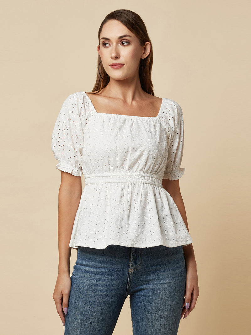 The White Cotton Schiffli Women Top With Ruched Waist And Lining is a stylish and elegant piece of clothing designed for women who appreciate comfort and fashion. This top is made of high-quality cotton material that is soft, breathable, and lightweight, making it perfect for wearing in warm weather.  The top is designed with a beautiful Schiffli embroidery pattern that gives it a unique and classy look. The ruched waist of the top accentuates the waistline, creating a flattering silhouette for the wearer. 