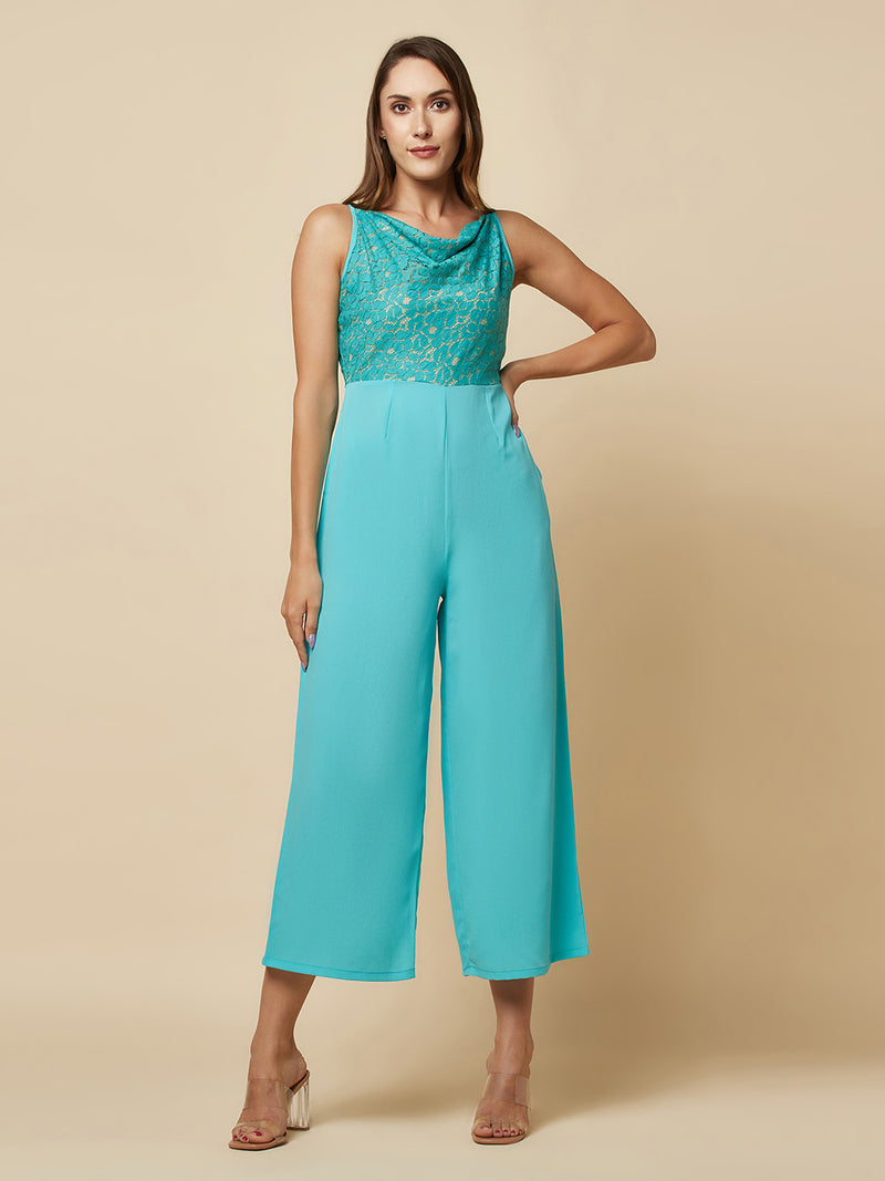 Blue cowl neck women jumpsuit with jacquard mesh body and crepe pants is a fashionable piece of clothing that is both elegant and comfortable. The cowl neck provides a flattering neckline that is both feminine and sophisticated.