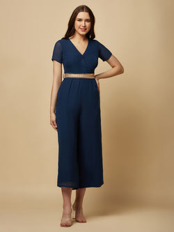 An Angrakkha style jumpsuit has a wrap-like design with a V-neckline and a side tie or belt closure. The jumpsuit may have a fitted bodice with wide-leg pants design.  The jumpsuit  is made from  polyester fabric with attached lining.  Golden Belt  clinches waist and gives it a more feminine look. Overall, a yellow color solid Angrakkha style women's jumpsuit with a belt is a stylish and comfortable outfit option for a variety of occasions.
