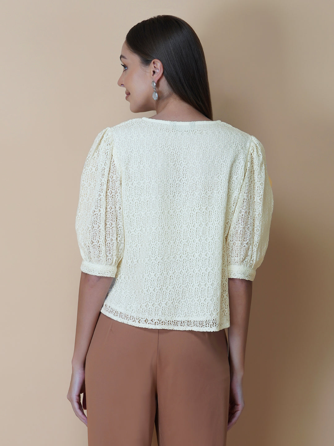 The Ivory Color Jacquard Mesh Women Top is a versatile and stylish piece of clothing that is perfect for both formal and casual occasions. The top features a classic V-neck design that is flattering for all body types, and it is adorned with a row of front buttons that add a touch of elegance and sophistication to the overall look.  Made from good-quality jacquard mesh fabric, this top is lightweight, breathable, and comfortable to wear all day long
