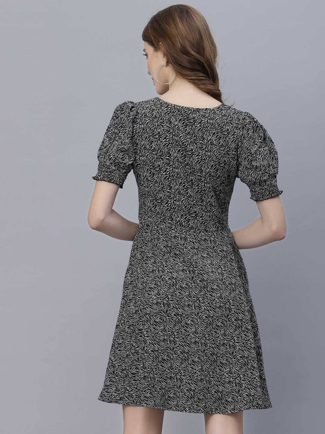 This printed short dress features a ruched neckline and smocked sleeves, creating a feminine and flirty look. The circular flare design adds a playful and fun touch to the dress, making it perfect for a summer day or a night out.