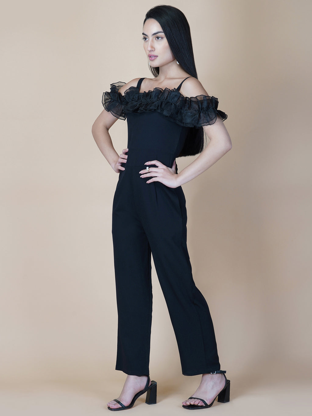 This black solid women's jumpsuit is the perfect combination of comfort and style. This jumpsuit features a tissue ruffle that adds a touch of feminine charm to the outfit. The jumpsuit has a sleeveless design with strap on shoulder, providing a stylish look