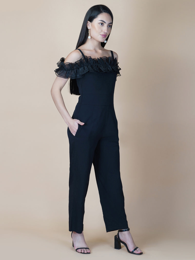This black solid women's jumpsuit is the perfect combination of comfort and style. This jumpsuit features a tissue ruffle that adds a touch of feminine charm to the outfit. The jumpsuit has a sleeveless design with strap on shoulder, providing a stylish look