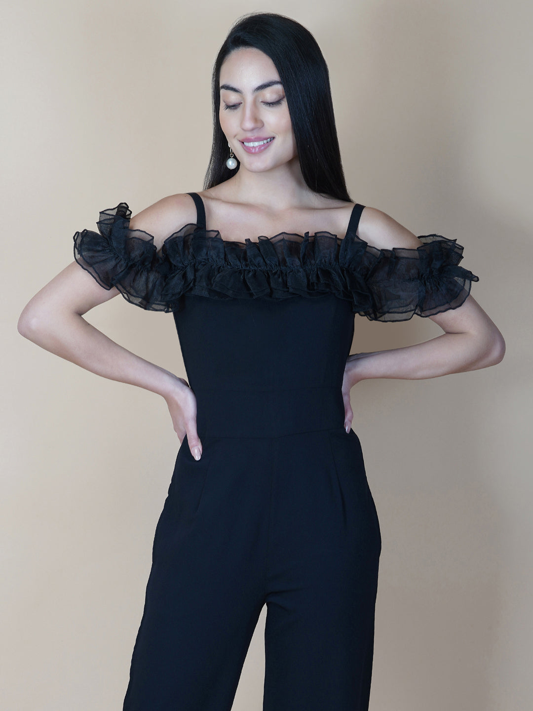 This black solid women's jumpsuit is the perfect combination of comfort and style. This jumpsuit features a tissue ruffle that adds a touch of feminine charm to the outfit. The jumpsuit has a sleeveless design with strap on shoulder, providing a stylish look
