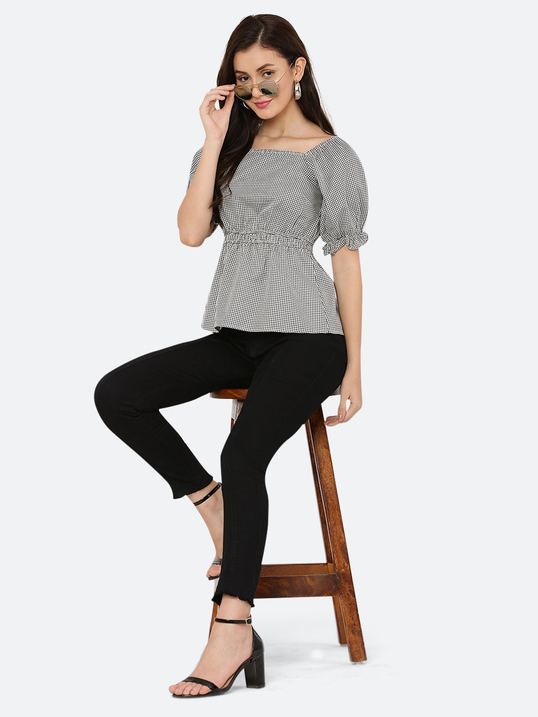 A grey gingham ruched waist women's top with gathered sleeves is a stylish and feminine garment. The top features a classic grey gingham pattern, with a fitted waistline that is gathered and ruched for a flattering silhouette. The gathered sleeves add a touch of volume and interest to the design.