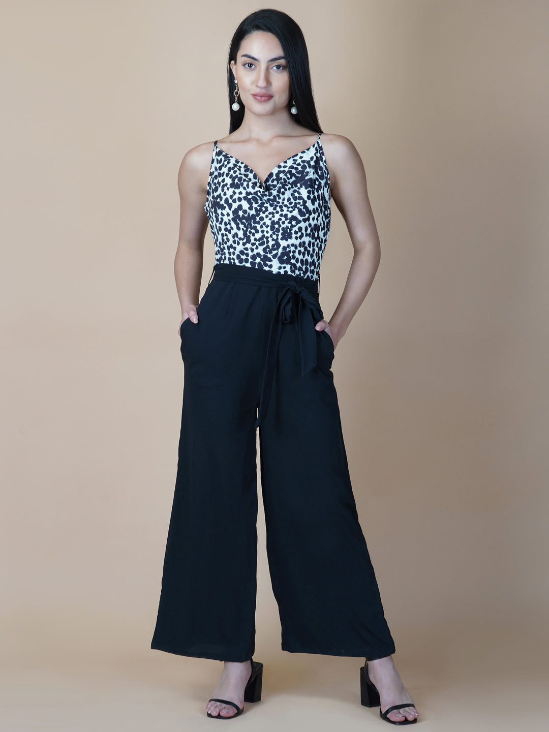 Black and white printed cowl neck jumpsuit is a stylish and versatile piece of clothing that can be worn for various occasions. It can be dressed up or down depending on the event and the accessories you choose to wear with it.