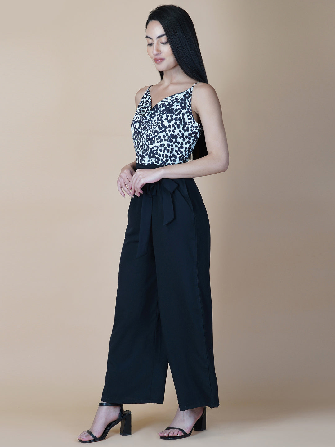 Black and white printed cowl neck jumpsuit is a stylish and versatile piece of clothing that can be worn for various occasions. It can be dressed up or down depending on the event and the accessories you choose to wear with it.