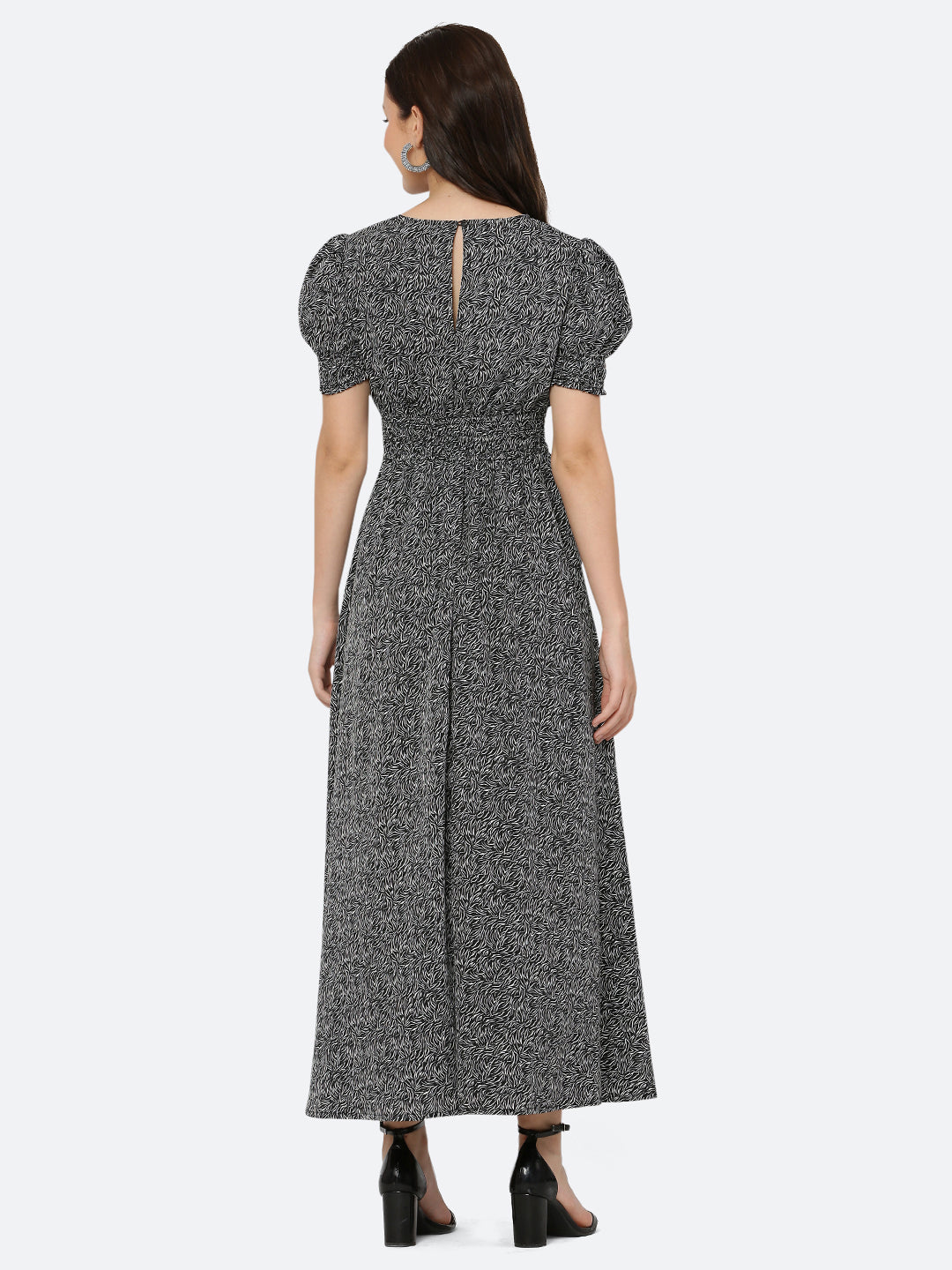 This black printed maxi dress features an abstract print that adds a touch of sophistication to the silhouette. The ruched waist and sleeves create a flattering and feminine shape, while the attached lining provides comfort and coverage. Perfect for both formal and casual occasions, this dress can be styled with statement earrings, strappy heels, and a clutch for a chic and effortless look.