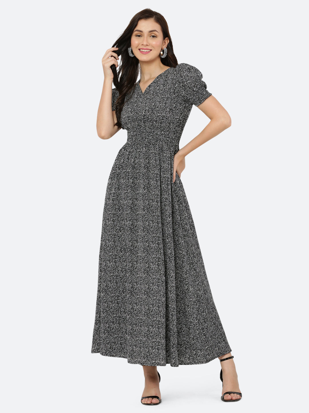 This black printed maxi dress features an abstract print that adds a touch of sophistication to the silhouette. The ruched waist and sleeves create a flattering and feminine shape, while the attached lining provides comfort and coverage. Perfect for both formal and casual occasions, this dress can be styled with statement earrings, strappy heels, and a clutch for a chic and effortless look.