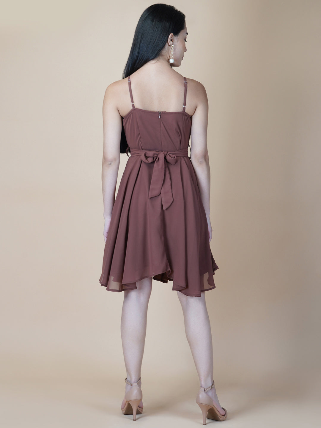 This beautiful brown color dress features a solid cowl neck design that drapes gracefully over the neckline. The circular hemline adds a unique touch to the dress, making it perfect for casual occasions.