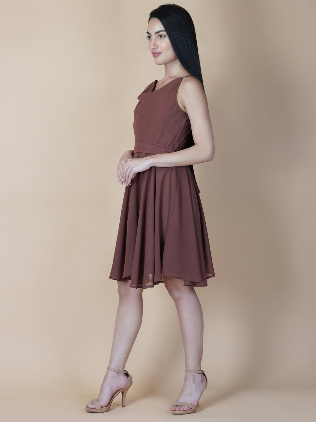 This beautiful brown color dress features a solid cowl neck design that drapes gracefully over the neckline. The circular hemline adds a unique touch to the dress, making it perfect for casual occasions.