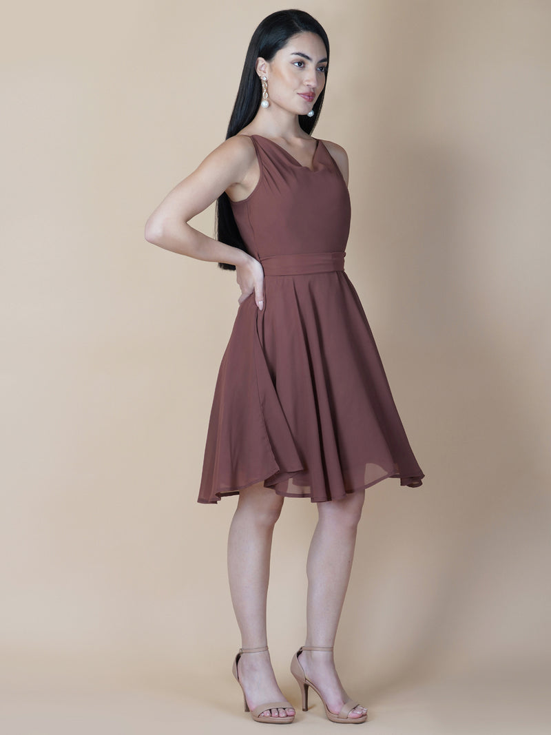 This beautiful brown color dress features a solid cowl neck design that drapes gracefully over the neckline. The circular hemline adds a unique touch to the dress, making it perfect for casual occasions.
