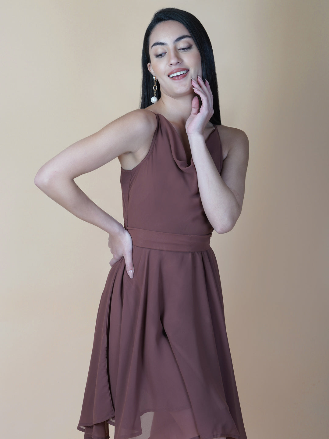 This beautiful brown color dress features a solid cowl neck design that drapes gracefully over the neckline. The circular hemline adds a unique touch to the dress, making it perfect for casual occasions.