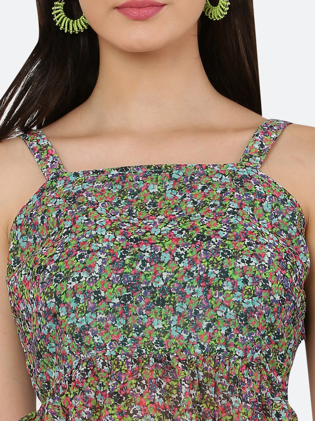 A green floral cami top for women with a frill at the waist is a stylish and feminine piece of clothing. The cami top is usually made of lightweight and breathable materials, making it perfect for warm weather.  The green floral pattern adds a pop of color and a touch of nature-inspired beauty to the top, while the frill at the waistline adds a playful and flirty touch.