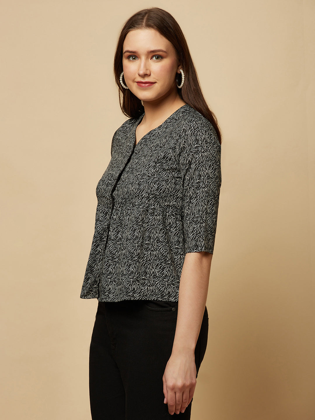 A black printed top with a front placket and ruched bust line is a stylish and elegant piece of clothing. The top has a simple and classic design with a front placket that adds a touch of sophistication to the outfit. The ruched bust line creates a flattering and feminine look, enhancing the wearer's curves.