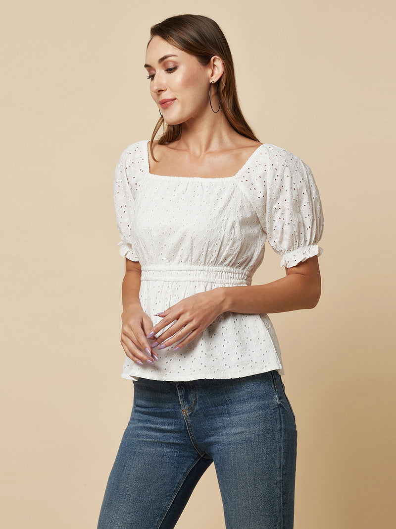 The White Cotton Schiffli Women Top With Ruched Waist And Lining is a stylish and elegant piece of clothing designed for women who appreciate comfort and fashion. This top is made of high-quality cotton material that is soft, breathable, and lightweight, making it perfect for wearing in warm weather.  The top is designed with a beautiful Schiffli embroidery pattern that gives it a unique and classy look. The ruched waist of the top accentuates the waistline, creating a flattering silhouette for the wearer. 
