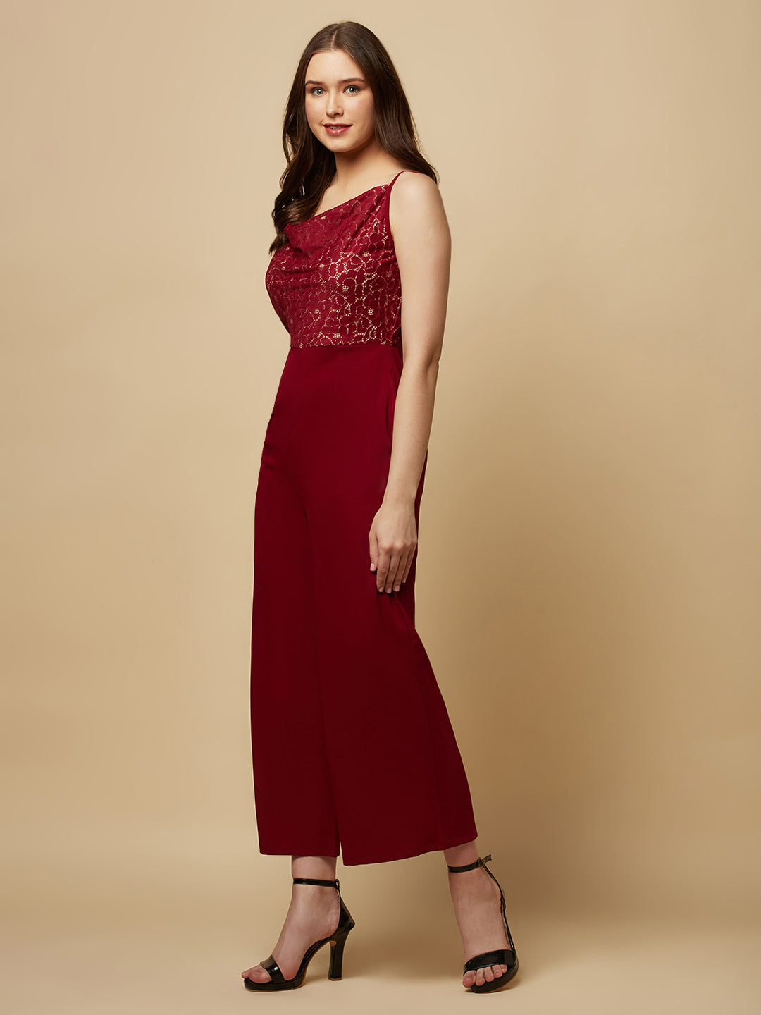 Burgundy cowl neck women jumpsuit with jacquard mesh body and crepe pants is a fashionable piece of clothing that is both elegant and comfortable. The cowl neck provides a flattering neckline that is both feminine and sophisticated.  The jacquard mesh body adds a touch of glamour and texture to the piece, while the crepe pants provide a smooth and comfortable fit.