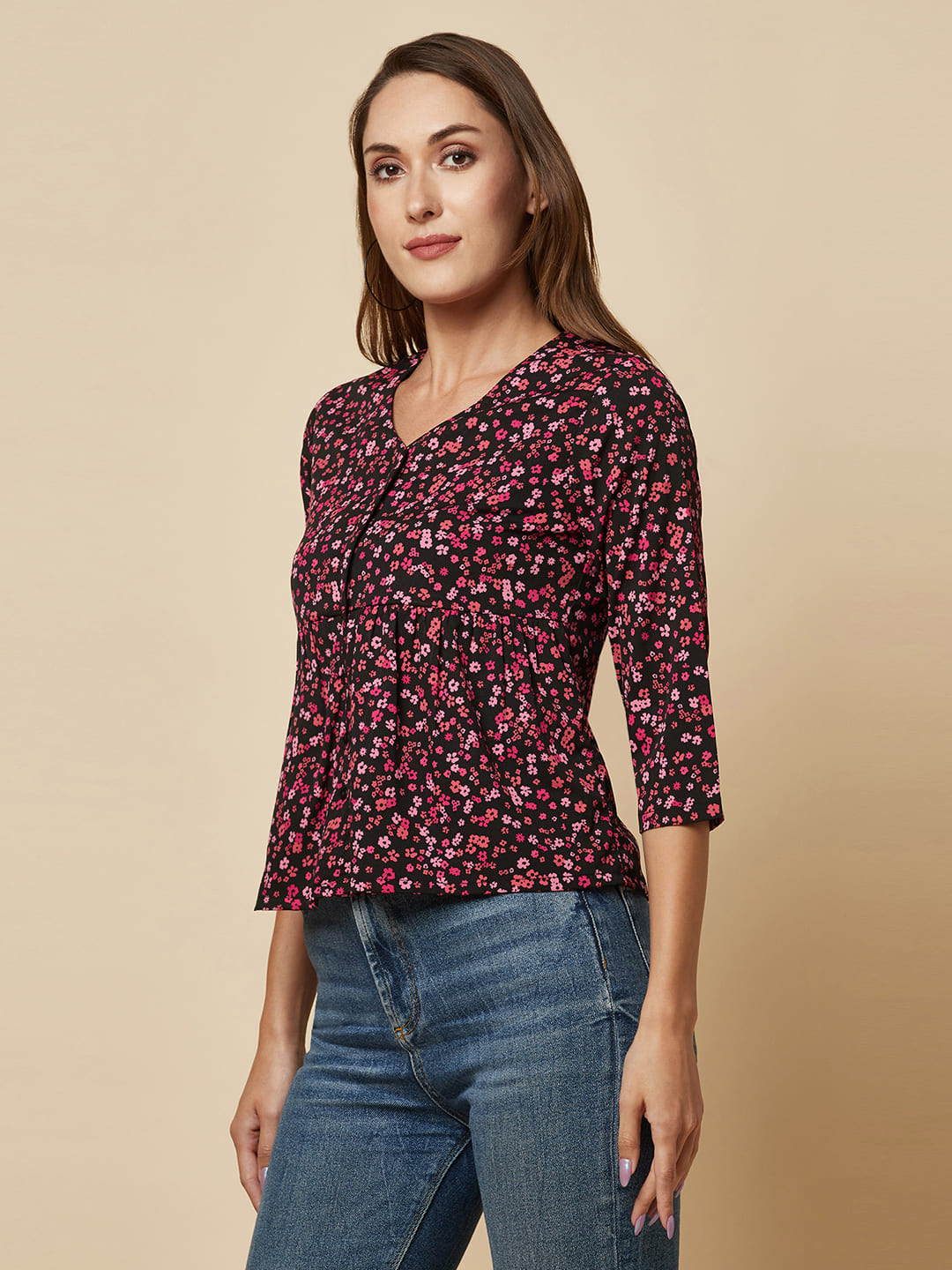A pink floral printed top with a front placket and ruched bust line is a stylish and elegant piece of clothing. The top has a simple and classic design with a front placket that adds a touch of sophistication to the outfit. The ruched bust line creates a flattering and feminine look, enhancing the wearer's curves. 