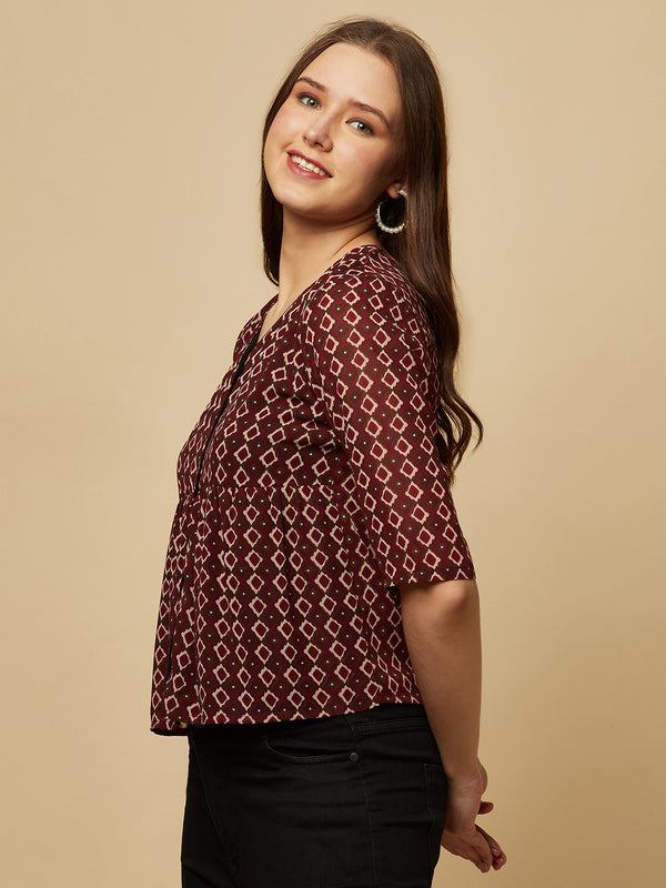 A brown printed top with a front placket and ruched bust line is a stylish and elegant piece of clothing. The top has a simple and classic design with a front placket that adds a touch of sophistication to the outfit. The ruched bust line creates a flattering and feminine look, enhancing the wearer's curves.