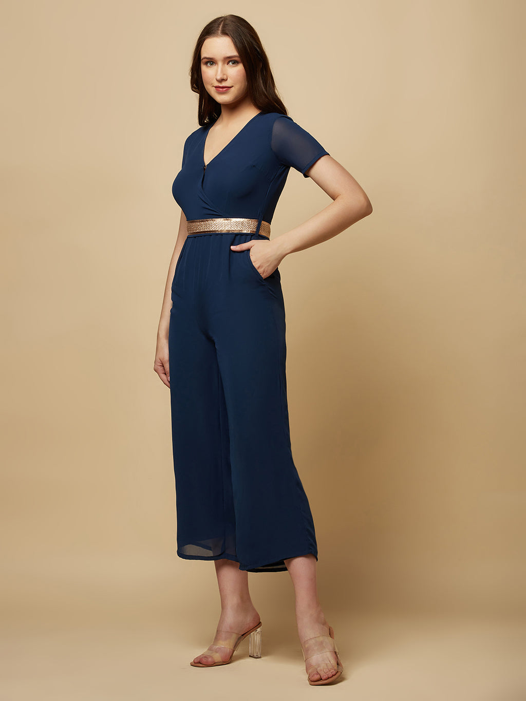 An Angrakkha style jumpsuit has a wrap-like design with a V-neckline and a side tie or belt closure. The jumpsuit may have a fitted bodice with wide-leg pants design.  The jumpsuit  is made from  polyester fabric with attached lining.  Golden Belt  clinches waist and gives it a more feminine look. Overall, a yellow color solid Angrakkha style women's jumpsuit with a belt is a stylish and comfortable outfit option for a variety of occasions.