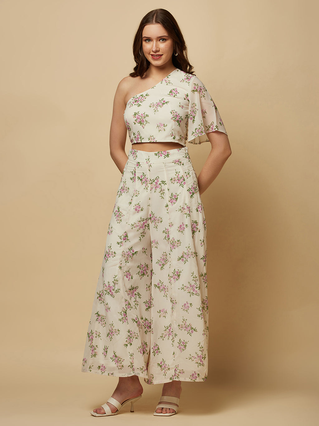 The White Floral Printed Palazzo With One Shoulder Crop Top Co-ords is a stylish and elegant outfit designed for women. This set features a white palazzo pant and a one-shoulder crop top, both adorned with a beautiful floral print in shades of pink, white, and green. The palazzo pants are made of a lightweight and breathable fabric that flows elegantly as you move, providing both comfort and style. 