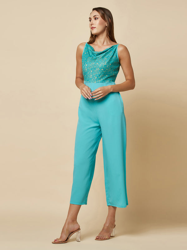 Blue cowl neck women jumpsuit with jacquard mesh body and crepe pants is a fashionable piece of clothing that is both elegant and comfortable. The cowl neck provides a flattering neckline that is both feminine and sophisticated.