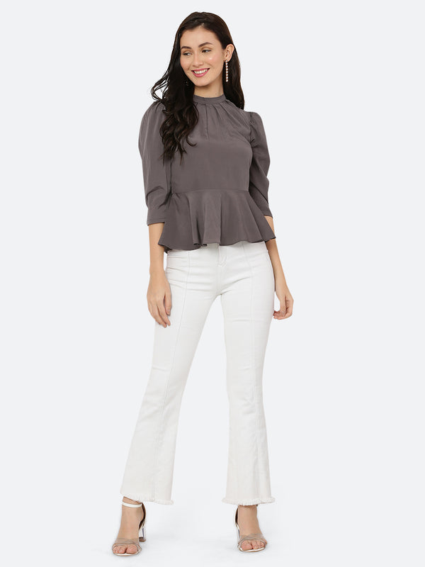 A grey colored women's top with a pleated neck and band collar is a stylish and sophisticated garment that can be worn for both casual and formal occasions. The pleated neck and band collar add a touch of elegance to the top, while the grey color gives it a classic and timeless look.