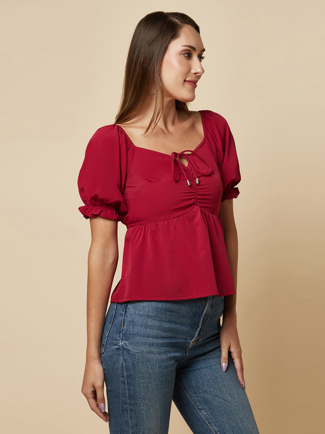 A Burgundy Solid Ruched Waist Peplum Top for Women is a stylish and flattering garment that is perfect for various occasions. The top features a beautiful shade of burgundy, which is perfect for adding a pop of color to any outfit. The ruched waistline creates a slimming effect, accentuating the natural curves of the body. The peplum detail adds a feminine and stylish touch to the design, making it perfect for a night out or a formal event.