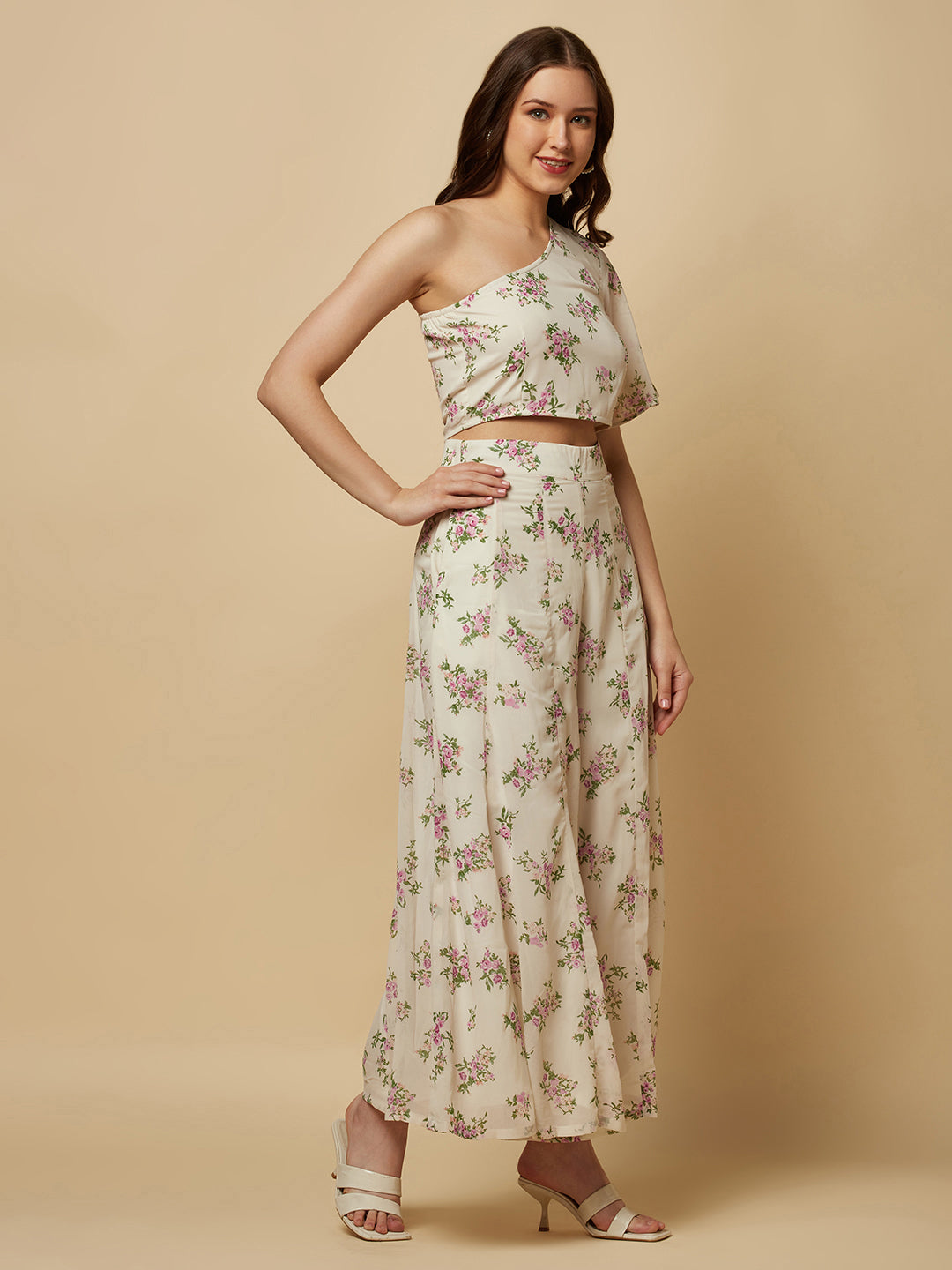 The White Floral Printed Palazzo With One Shoulder Crop Top Co-ords is a stylish and elegant outfit designed for women. This set features a white palazzo pant and a one-shoulder crop top, both adorned with a beautiful floral print in shades of pink, white, and green. The palazzo pants are made of a lightweight and breathable fabric that flows elegantly as you move, providing both comfort and style. 