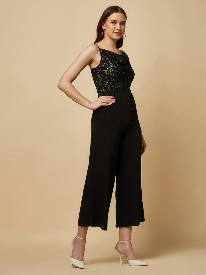 Black cowl neck women jumpsuit with jacquard mesh body and crepe pants is a fashionable piece of clothing that is both elegant and comfortable. The cowl neck provides a flattering neckline that is both feminine and sophisticated.  The jacquard mesh body adds a touch of glamour and texture to the piece, while the crepe pants provide a smooth and comfortable fit.