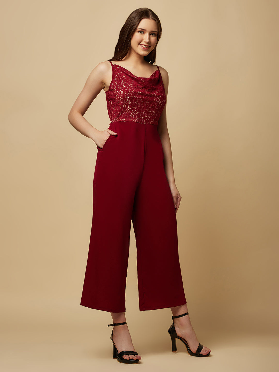 Burgundy cowl neck women jumpsuit with jacquard mesh body and crepe pants is a fashionable piece of clothing that is both elegant and comfortable. The cowl neck provides a flattering neckline that is both feminine and sophisticated.  The jacquard mesh body adds a touch of glamour and texture to the piece, while the crepe pants provide a smooth and comfortable fit.