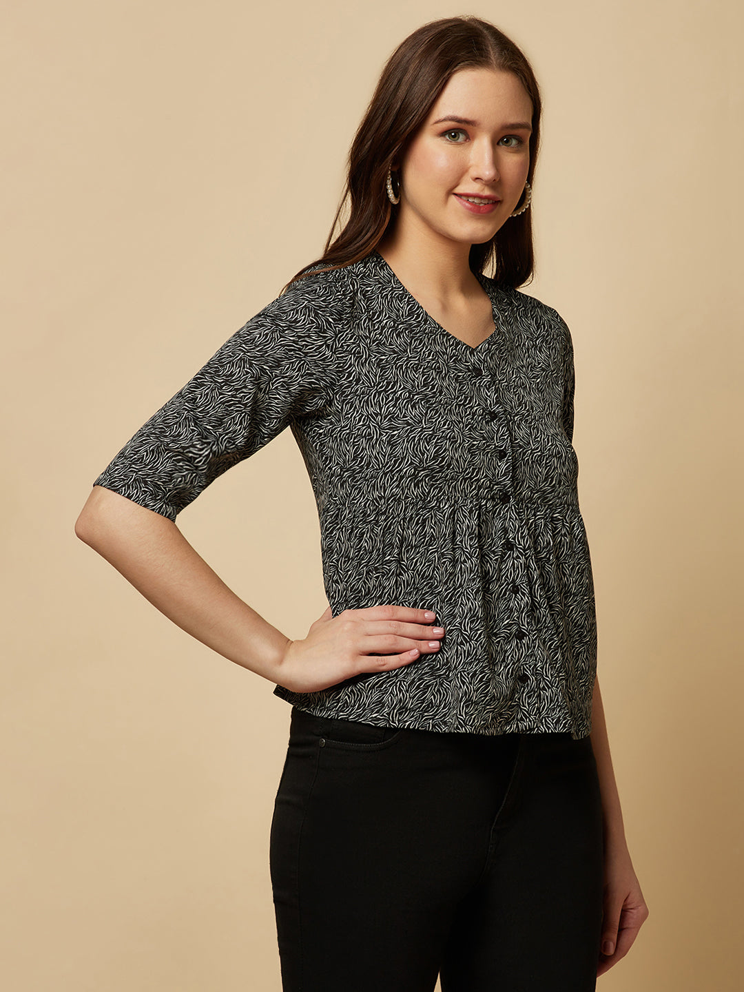 A black printed top with a front placket and ruched bust line is a stylish and elegant piece of clothing. The top has a simple and classic design with a front placket that adds a touch of sophistication to the outfit. The ruched bust line creates a flattering and feminine look, enhancing the wearer's curves.