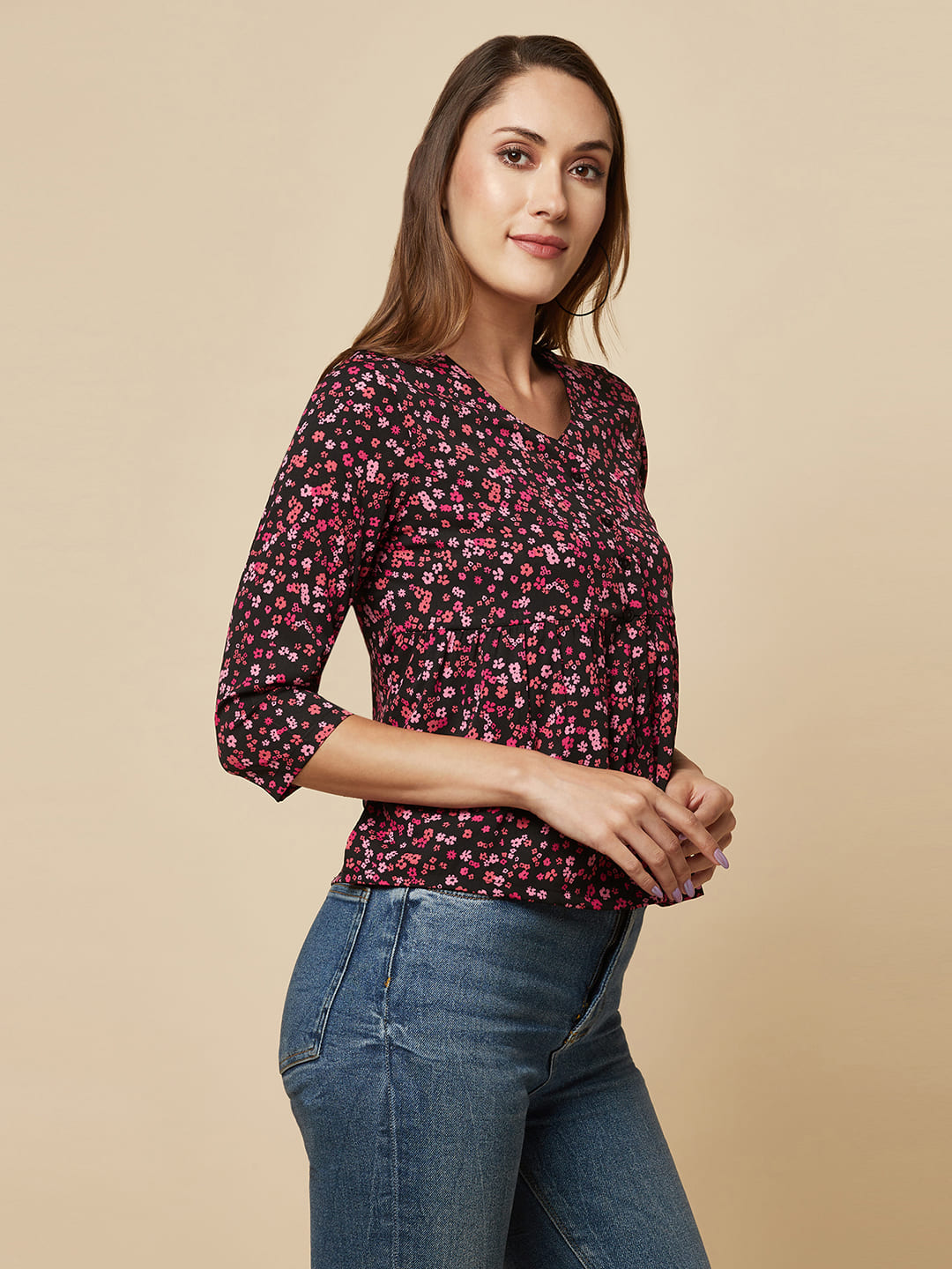 A pink floral printed top with a front placket and ruched bust line is a stylish and elegant piece of clothing. The top has a simple and classic design with a front placket that adds a touch of sophistication to the outfit. The ruched bust line creates a flattering and feminine look, enhancing the wearer's curves. 
