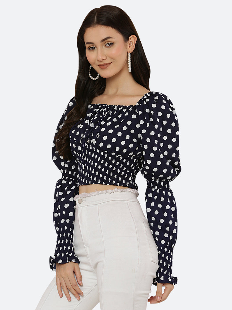 Blue polka dot smocked crop top for women is a trendy and stylish garment that features a fitted and stretchy smocked bodice, with a cropped hem that sits above the waistline. The top is adorned with small polka dots that add a playful and feminine touch.  This type of top is versatile and can be styled in a variety of ways. 