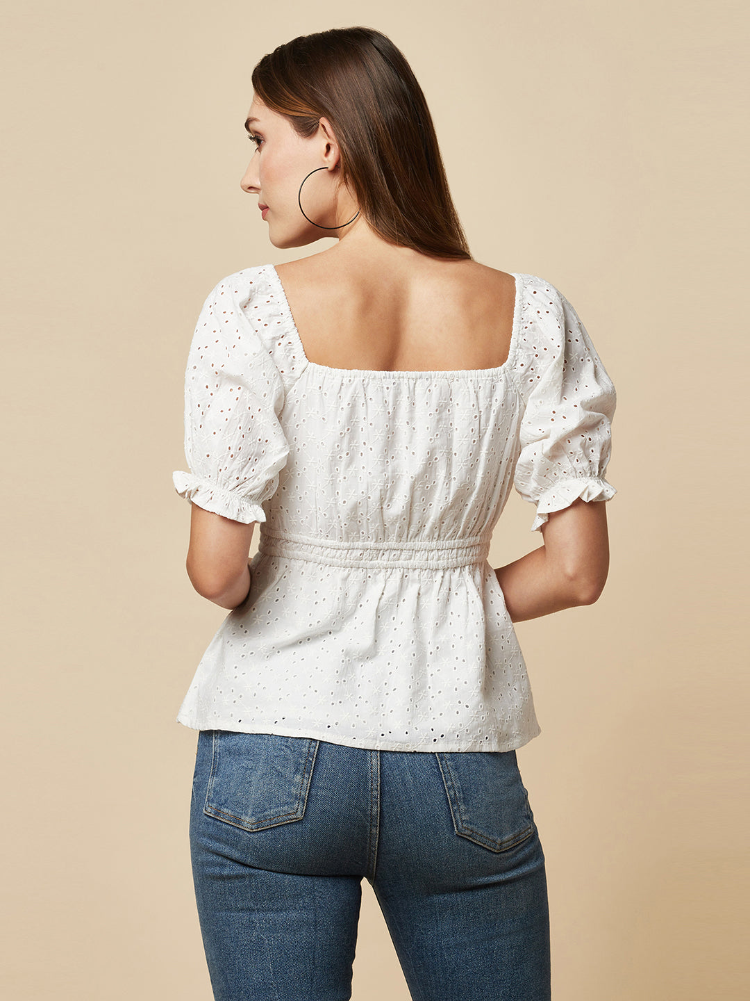 The White Cotton Schiffli Women Top With Ruched Waist And Lining is a stylish and elegant piece of clothing designed for women who appreciate comfort and fashion. This top is made of high-quality cotton material that is soft, breathable, and lightweight, making it perfect for wearing in warm weather.  The top is designed with a beautiful Schiffli embroidery pattern that gives it a unique and classy look. The ruched waist of the top accentuates the waistline, creating a flattering silhouette for the wearer. 