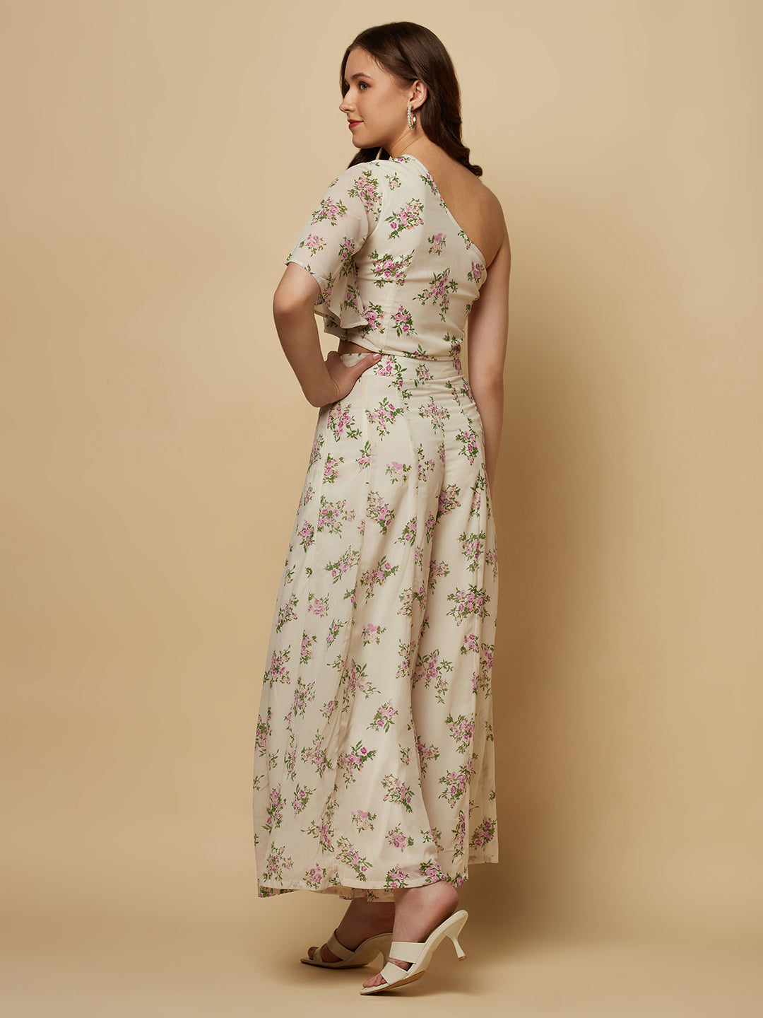 The White Floral Printed Palazzo With One Shoulder Crop Top Co-ords is a stylish and elegant outfit designed for women. This set features a white palazzo pant and a one-shoulder crop top, both adorned with a beautiful floral print in shades of pink, white, and green. The palazzo pants are made of a lightweight and breathable fabric that flows elegantly as you move, providing both comfort and style. 