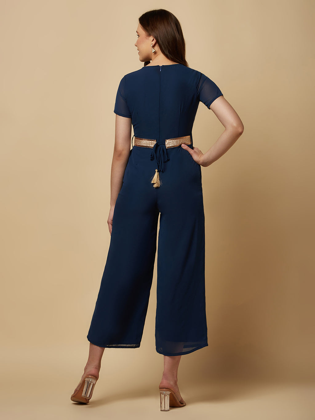 An Angrakkha style jumpsuit has a wrap-like design with a V-neckline and a side tie or belt closure. The jumpsuit may have a fitted bodice with wide-leg pants design.  The jumpsuit  is made from  polyester fabric with attached lining.  Golden Belt  clinches waist and gives it a more feminine look. Overall, a yellow color solid Angrakkha style women's jumpsuit with a belt is a stylish and comfortable outfit option for a variety of occasions.