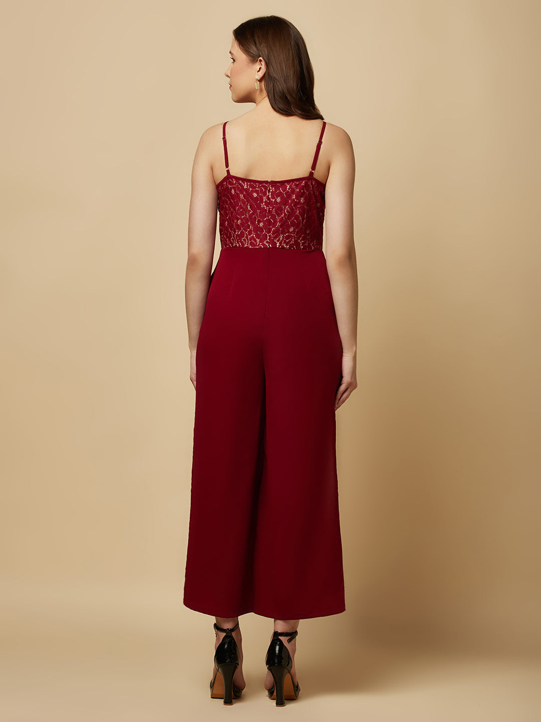 Burgundy cowl neck women jumpsuit with jacquard mesh body and crepe pants is a fashionable piece of clothing that is both elegant and comfortable. The cowl neck provides a flattering neckline that is both feminine and sophisticated.  The jacquard mesh body adds a touch of glamour and texture to the piece, while the crepe pants provide a smooth and comfortable fit.