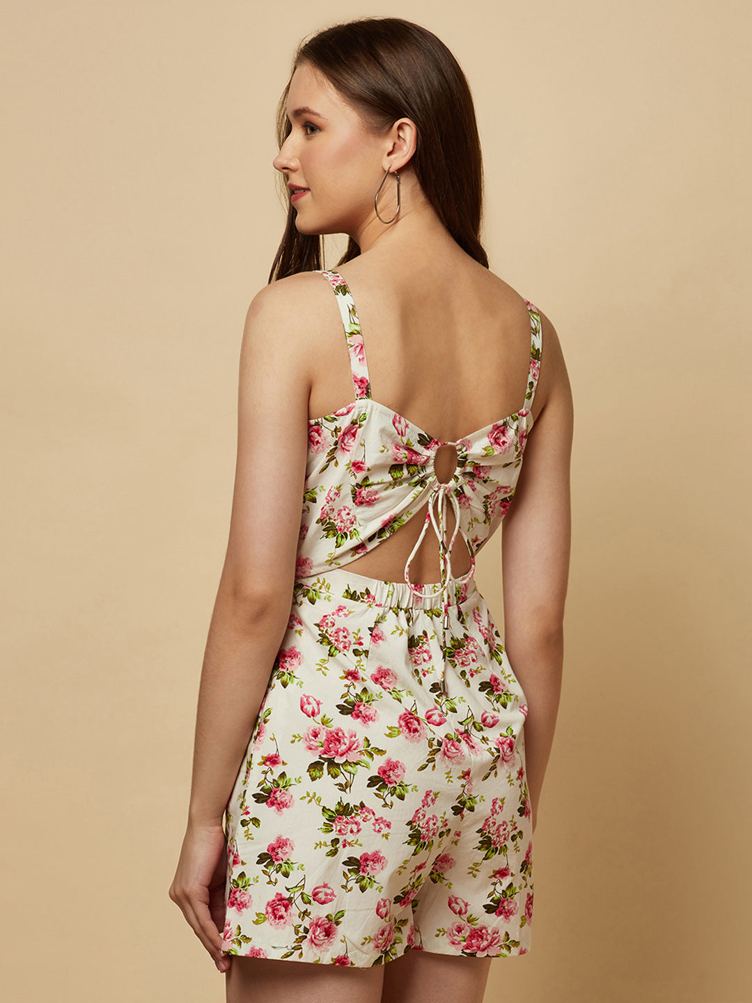 This white floral printed cotton jumpsuit is a perfect combination of style and comfort. The floral print adds a touch of femininity and elegance to the outfit, while the cotton fabric ensures breathability and ease of movement.  The jumpsuit features a back drawstring that allows for an adjustable fit, ensuring that it flatters your body shape perfectly. The drawstring also adds a touch of visual interest to the back of the jumpsuit, making it unique and eye-catching.
